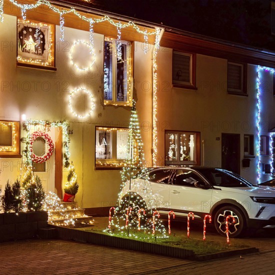 Christmassy kitschy illuminated façade of a row house in Gelsenkirchen-Ückendorf in the evening,