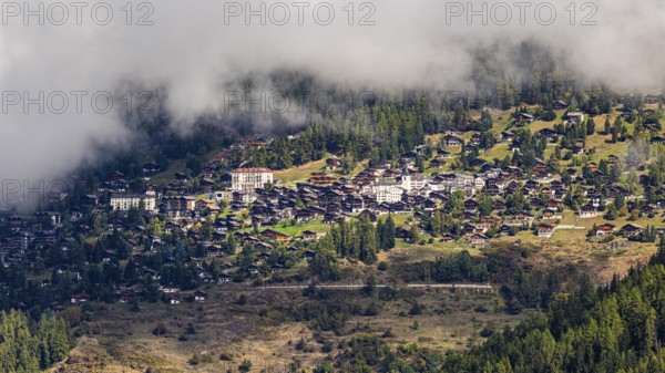 Fog is gathering over the mountain village of Saint-Luc, Val d'Anniviers, Valais Alps, Canton of