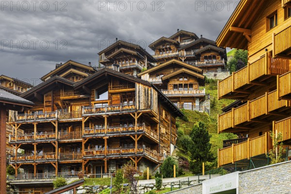 Dark clouds over wooden holiday homes, Grimentz, Val d'Anniviers, Valais Alps, Canton of Valais,