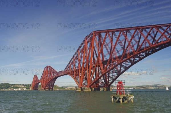 A distinctive red bridge spanning a wide river under clear skies, railway bridge, Firth of Forth,