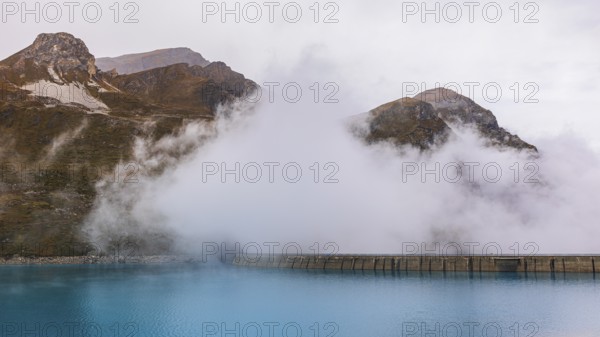 Fog rises over the dam of the Lac de Moiry Reservoir, Val d'Anniviers, Valais Alps, Canton of
