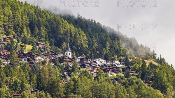 Rising fog over the mountain village of Saint-Luc, Val d'Anniviers, Valais Alps, Canton of Valais,