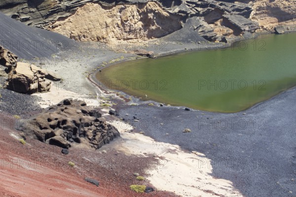 Volcanic crater and green lagoon with contrasting colors and rock formations, El Golfo, Lanzarote