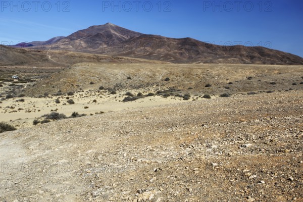 Wide, dry hilly landscape with a distant mountain under clear skies, Playa Blanca Lanzarote, Canary