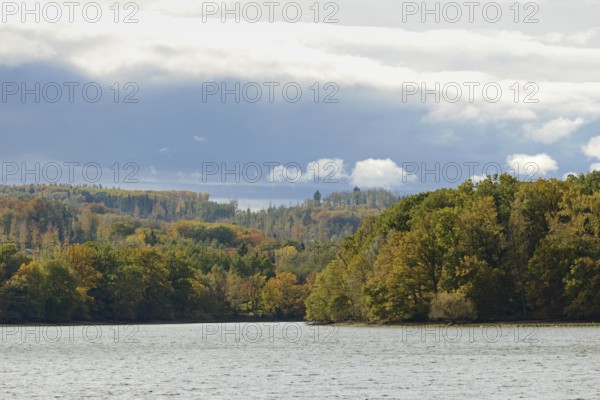 View over Lake Möhnesee, mixed autumn forest on the shore, rising rain clouds, Möhnetalsperre,