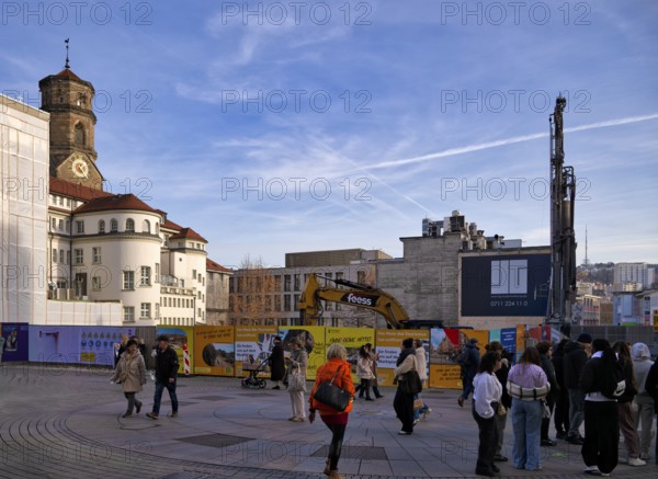 Passers-by, excavator, construction site, construction fence, controversial construction project of