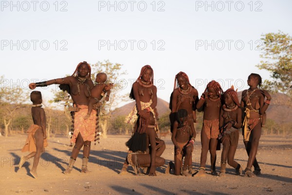 Group of Himba children and woman, evening mood, traditional Himba village, Kaokoveld, Kunene,