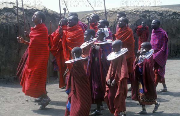 Maasai men and girls in their village in the Ngorongoro Crater dancing for tourists, Tanzania,