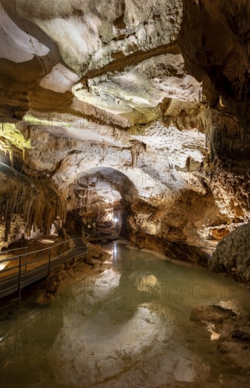 Stalactites and stalagmites, reflection in a small underground lake, rock formations in a