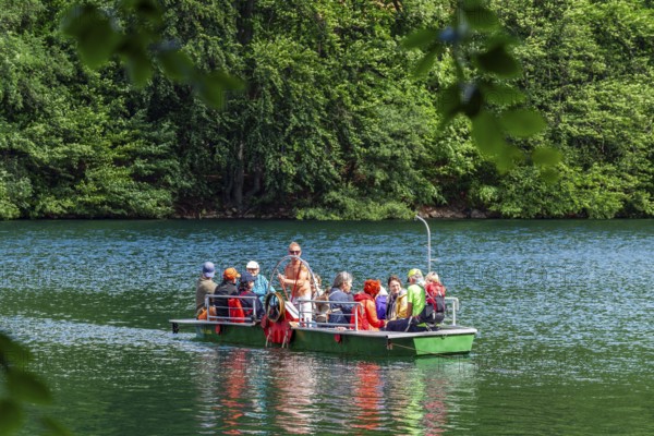 Manually operated ferry with ferryman and passengers, Lake Schmaler Luzin, Feldberg Lake District,