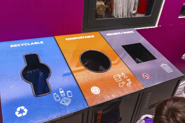 Colorful recycling bins at an airport promoting waste separation into recyclable, compostable, and