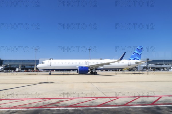 Modern passenger airplane parked on the tarmac at a bustling airport, preparing for its next flight