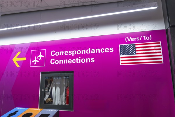 Bright pink airport sign with airplane icons and the flag of the united states of america, guiding