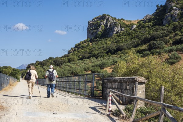 Hiking older couple, bridge Viaducto de Zaframagón, cycle path Via Verde de la Sierra, Puerto