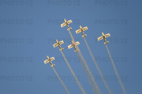 Stunt aerobatic planes performing stunts in blue sky with smoke trail. Concept of teamwork,