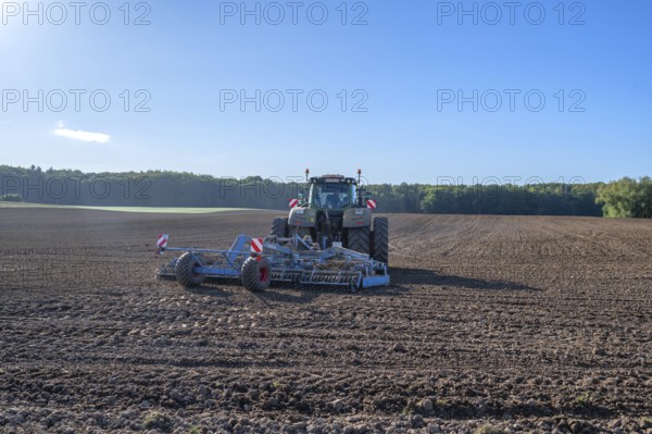 Field treatment of the agricultural cooperative with a large tractor with harrow, Othenstorf,