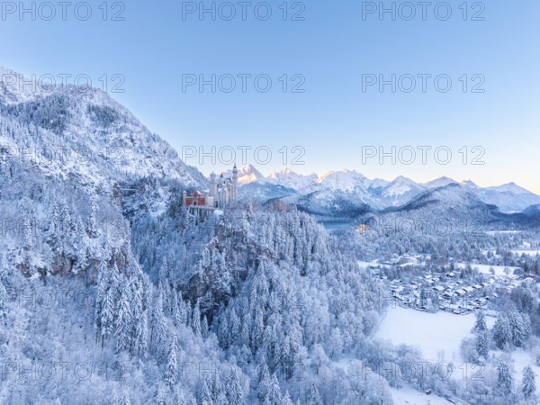 Neuschwanstein Castle is nestled in a quiet, snow-covered alpine landscape at dawn, Schwangau near