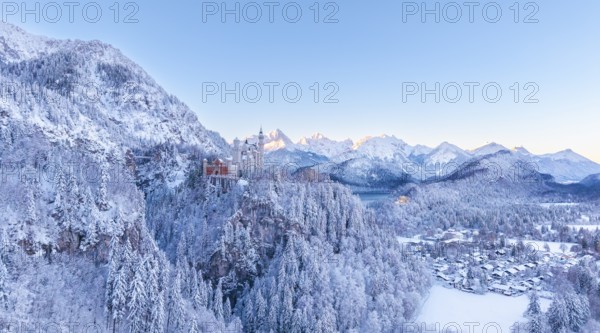 The picturesque Neuschwanstein Castle in winter surrounded by snow-capped mountains and forests at