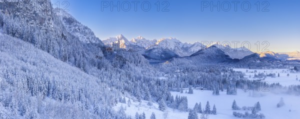 Wide snowy mountain landscape with clear skies and a wide view of the Alps, Neuschwanstein Castle,