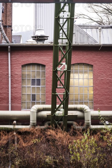 District heating pipeline in front of old industrial buildings on the banks of the Wupper,