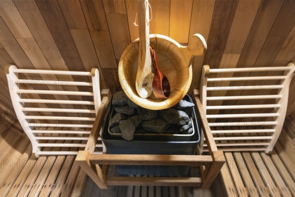 Steam and hot stone wooden cedar compact sauna interior with heating stone electrical device, hot
