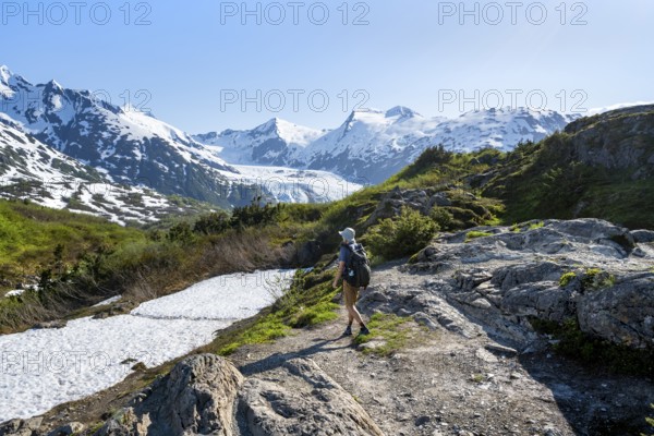 Hikers on the Portage Pass Trail, snow-covered mountains and Portage Glacier glaciers, near