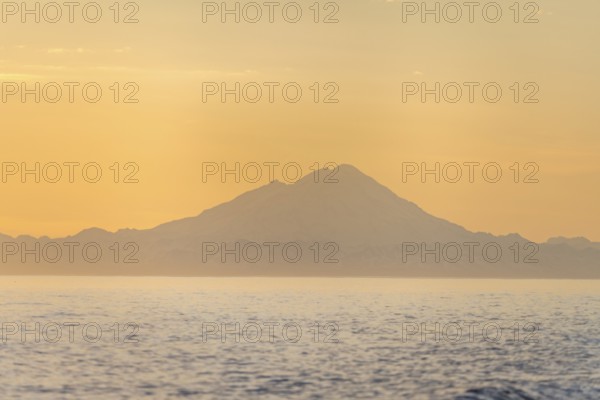 View of Cook Inlet on white mountain peaks of Mount Redoubt at sunset, midnight sun, Aleutian