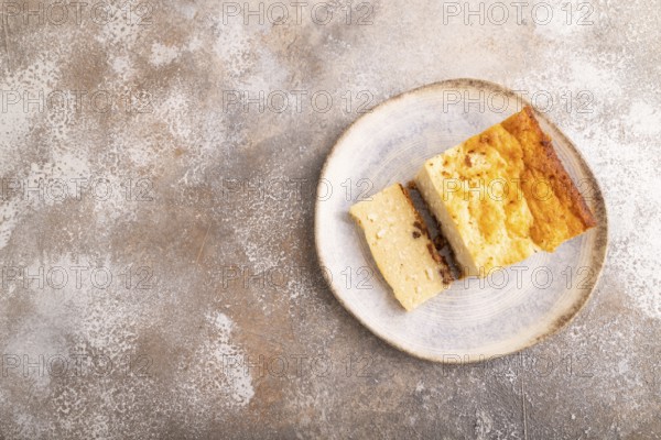 ?ottage cheese ?asserole, Curd cake, with dried apricots and raisins on brown concrete background,