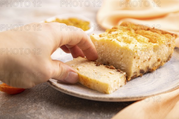 ?ottage cheese ?asserole, Curd cake, with dried apricots and raisins with hand on brown concrete