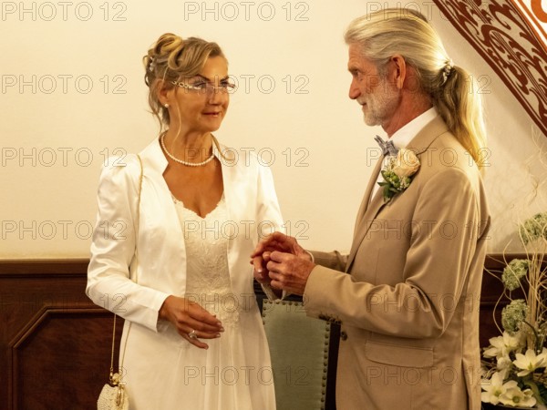 Elderly couple's wedding, registry office, attach rings