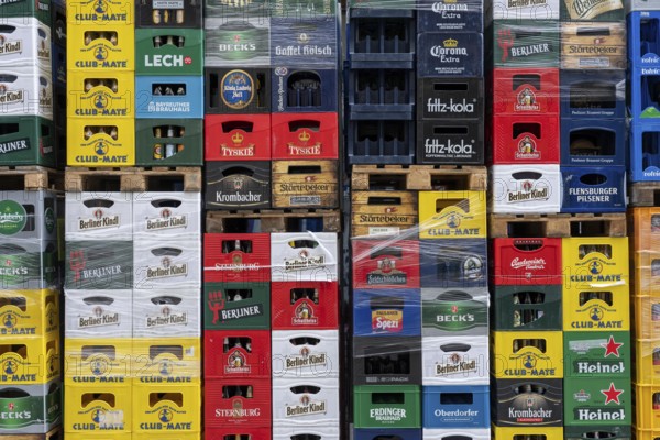 Empty beverage crates, from various manufacturers, bottling, types, stacked at a restaurant, for