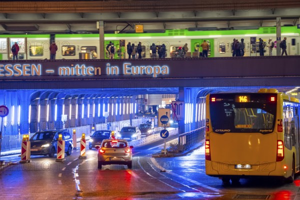 The main train station in Essen, blue illuminated underpass, bus station, am Europaplatz, train on