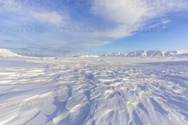 Desolate windswept snow covered Arctic landscape at Mohnbukta, bay at the western shore of