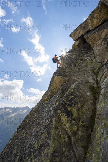 Female mountaineer on steep rock face on the secured via ferrata Krokodil-Bergsee am
