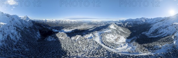 Wonderful winter landscape with Zugspitze, blue sky and snow, mountains and mountain valley, aerial
