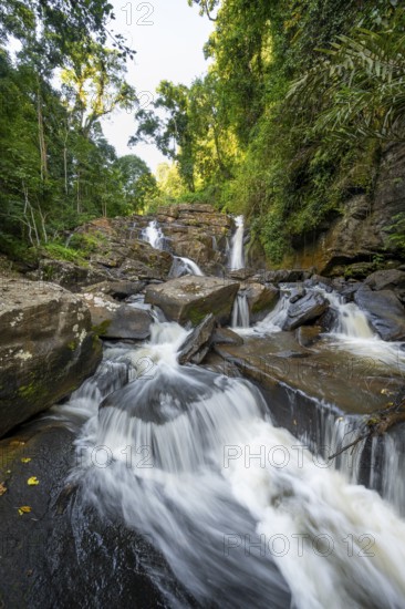 Derema Waterfall flows through thick vegetation, tropical rainforest in Amani Nature Forest