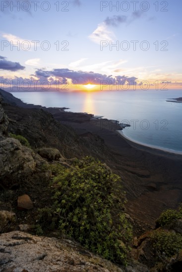 View from steep cliffs to sea and coast with sun stars, Mirador del Porrito viewpoint at sunset,