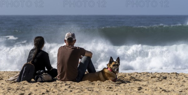 Tourists watch the waves of the Atlantic on the rocky plateau of Sito, also known as Forte São