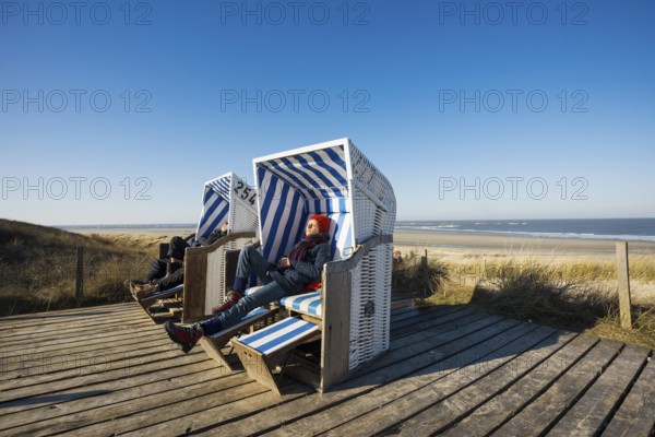 Beach chairs in the dunes and blue sky in winter, Spiekeroog, East Frisian Islands, Lower Saxony,
