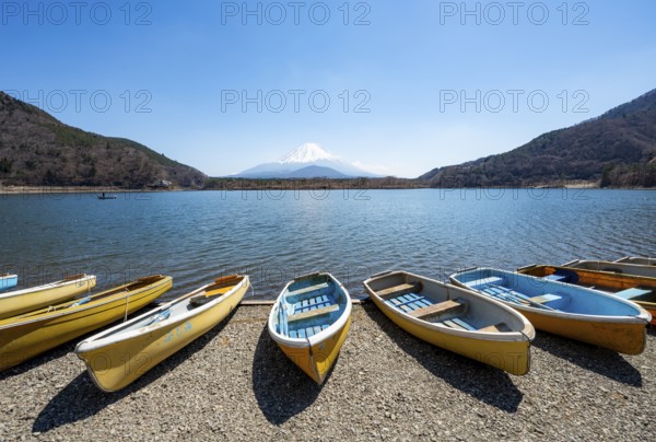 Rowing boats on shore, view across the lake to Mt Fuji volcano, Motosu Lake, Yamanashi Prefecture,