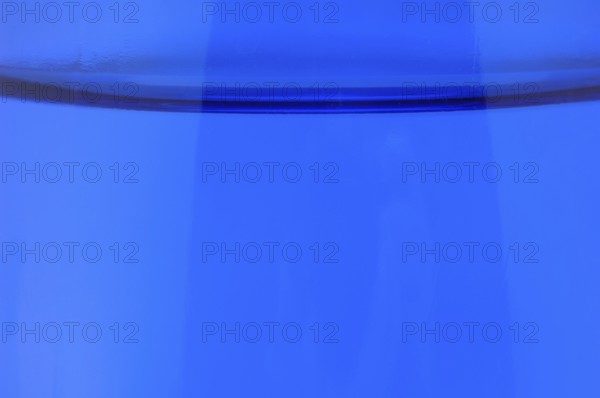 Glass with mineral water, small carbonated pearls on the edge of the glass, drinking water