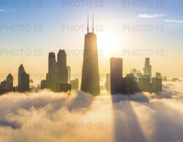 City scape emerging from a dense enveloping fog in sunrise and skyscrapers piercing the haze, big