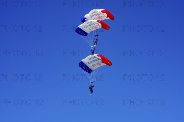 Skydivers during an aerial acrobatic performance as part of an air show at the Fliegerbergfest of