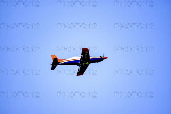 An RC model of a Pilatus PC-21 with advertising for the Swiss watch brand Breitling during a flight