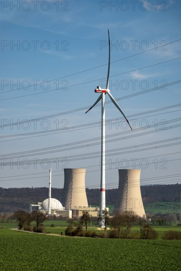 Distant view of the Grohnde nuclear power plant, dominated by a wind turbine, power lines in the