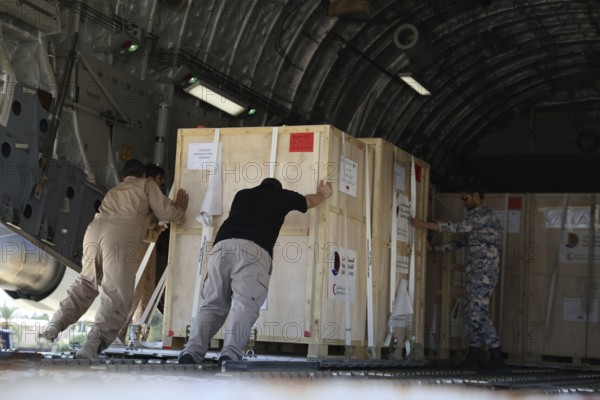 Members of the Qatari Air Force unload humanitarian aid supplies from a transport aircraft at