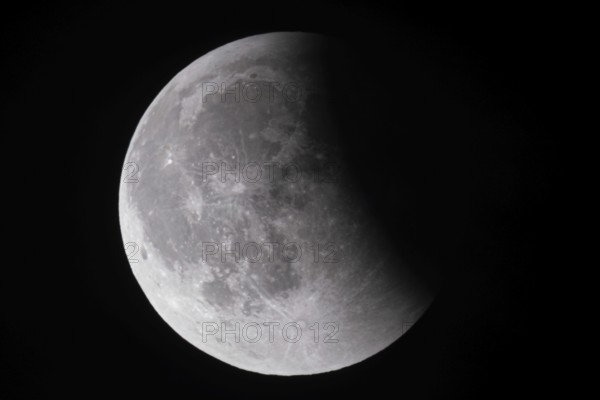 After a total lunar eclipse, the moon appears shortly after its rise in the evening sky as a