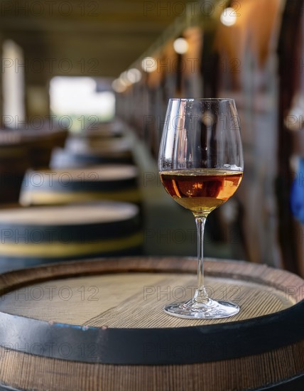 Glass of 10-year-old tawny wine placed on a barrel in a vineyard restaurant, AI generated