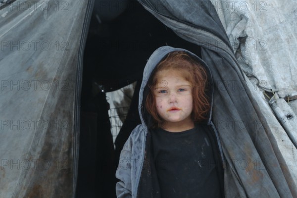 Displaced Syrian families and children living in refugee camps during harsh winter conditions,
