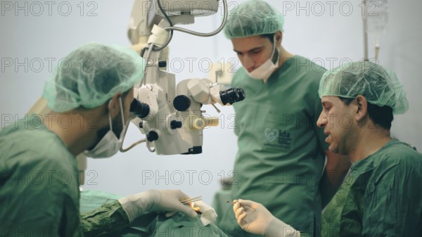 Several doctors performing a complex surgical operation inside an operating room for a displaced
